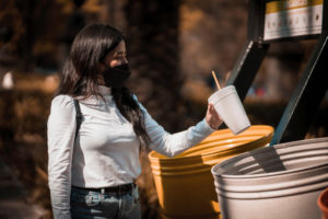 woman throwing cup into bin